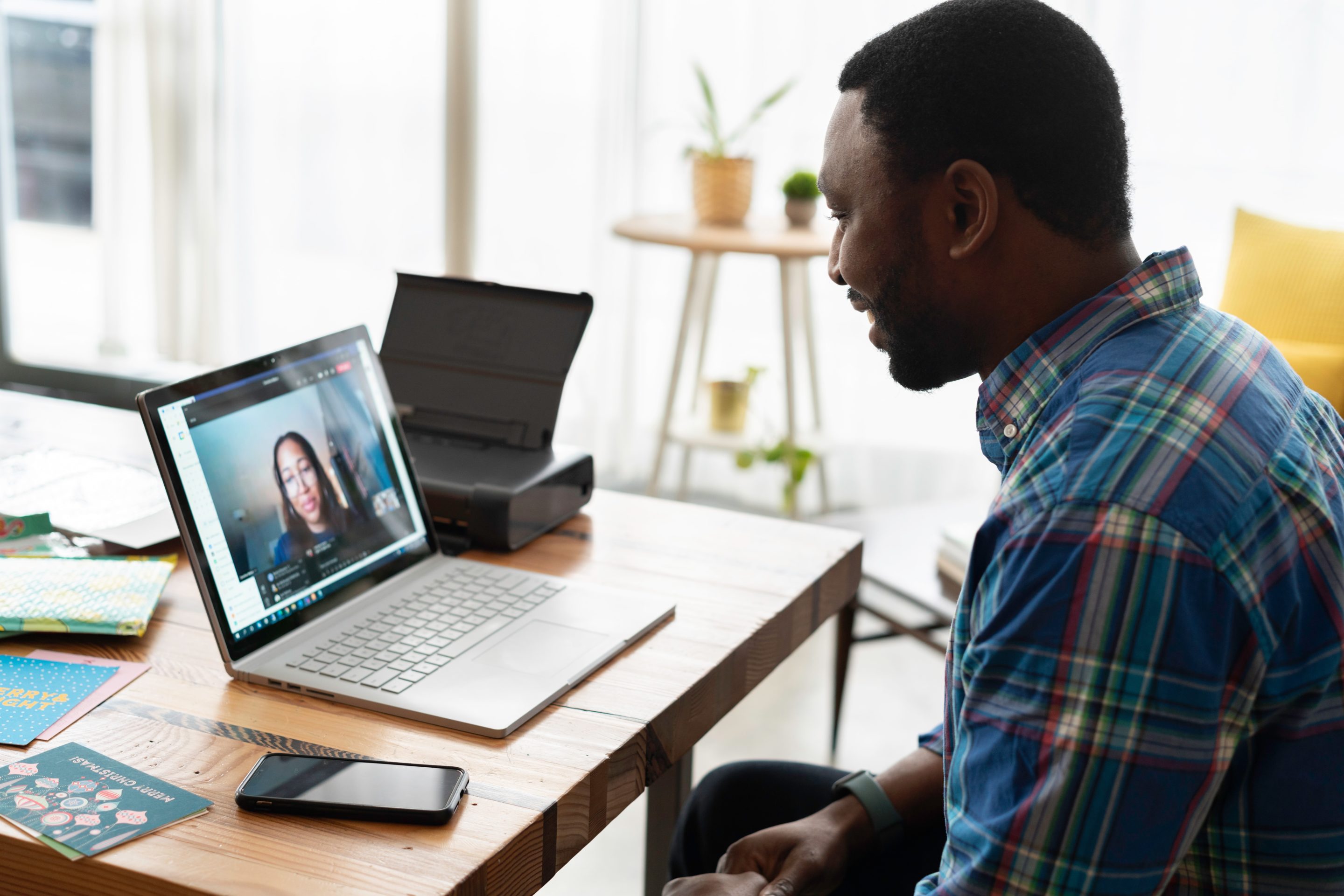 Man sitting on a desk having an online meeting with a woman