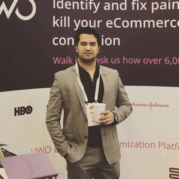 Rajat Man in a suit standing at a conference